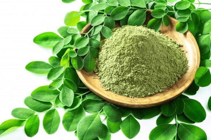 kratom powder in a bowl with leaves